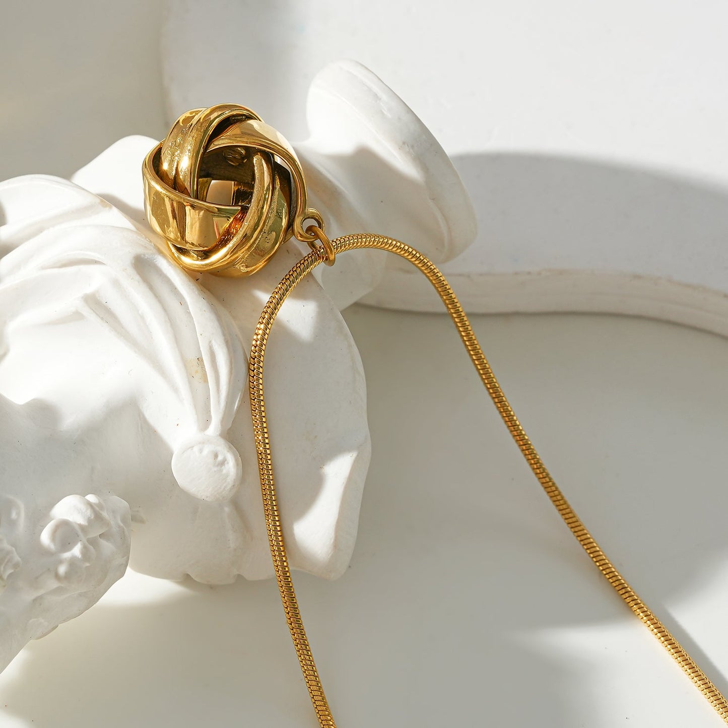 JASPUR: Snakeskin Chain Necklace with Love-Knot Pendant in Gold