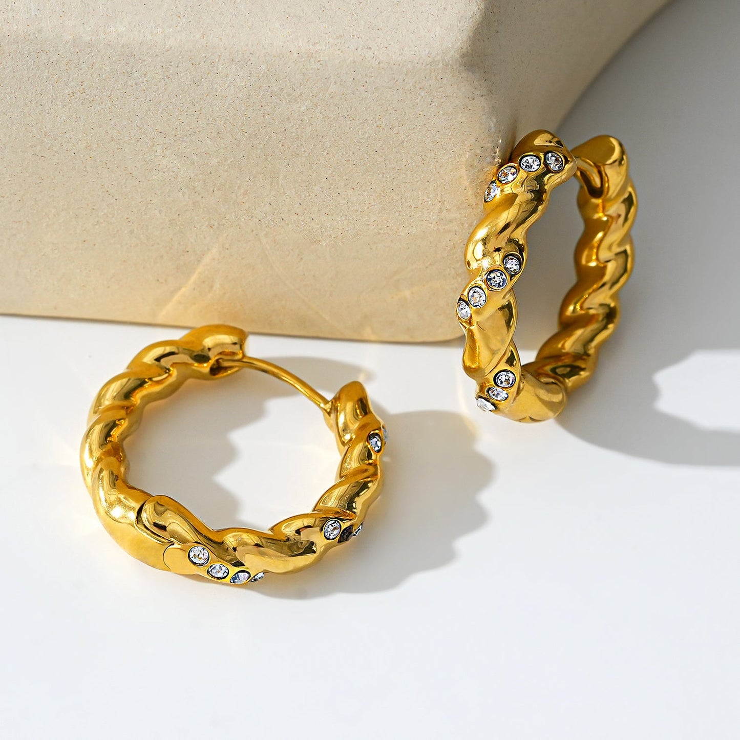 Style KAMENZ: Twisted Textured Hoop Earrings with Zirconia Embellishments.