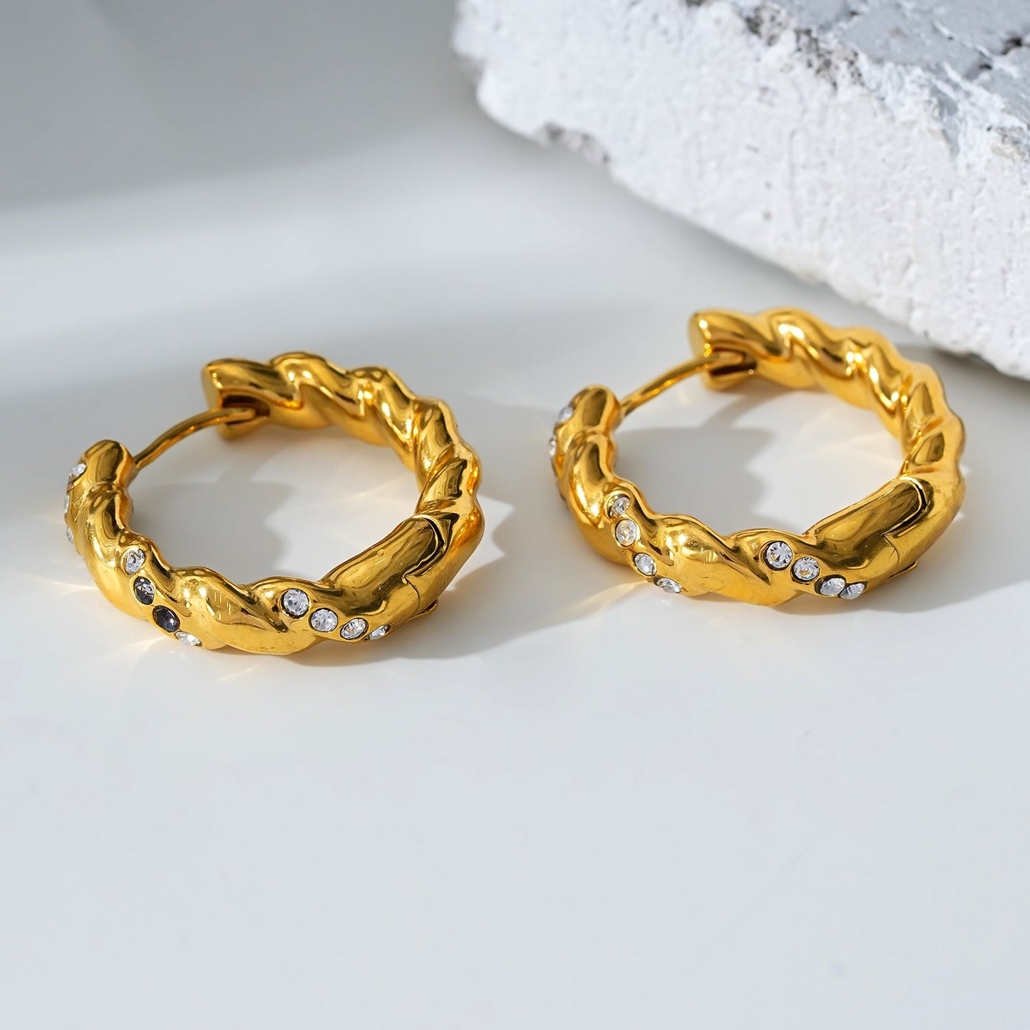 Style KAMENZ: Twisted Textured Hoop Earrings with Zirconia Embellishments.