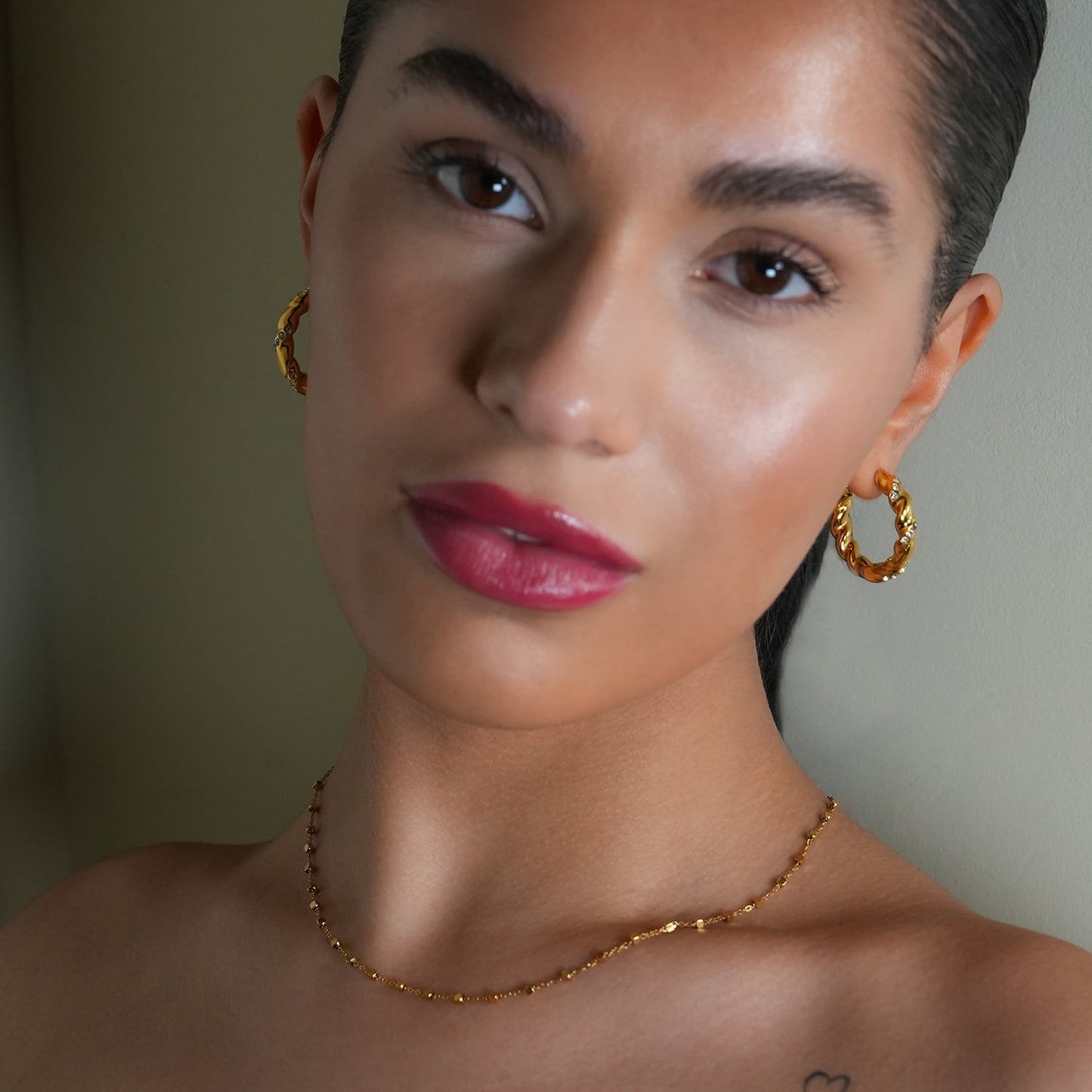 Style KAMENZ: Twisted Textured Hoop Earrings with Zirconia Embellishments.