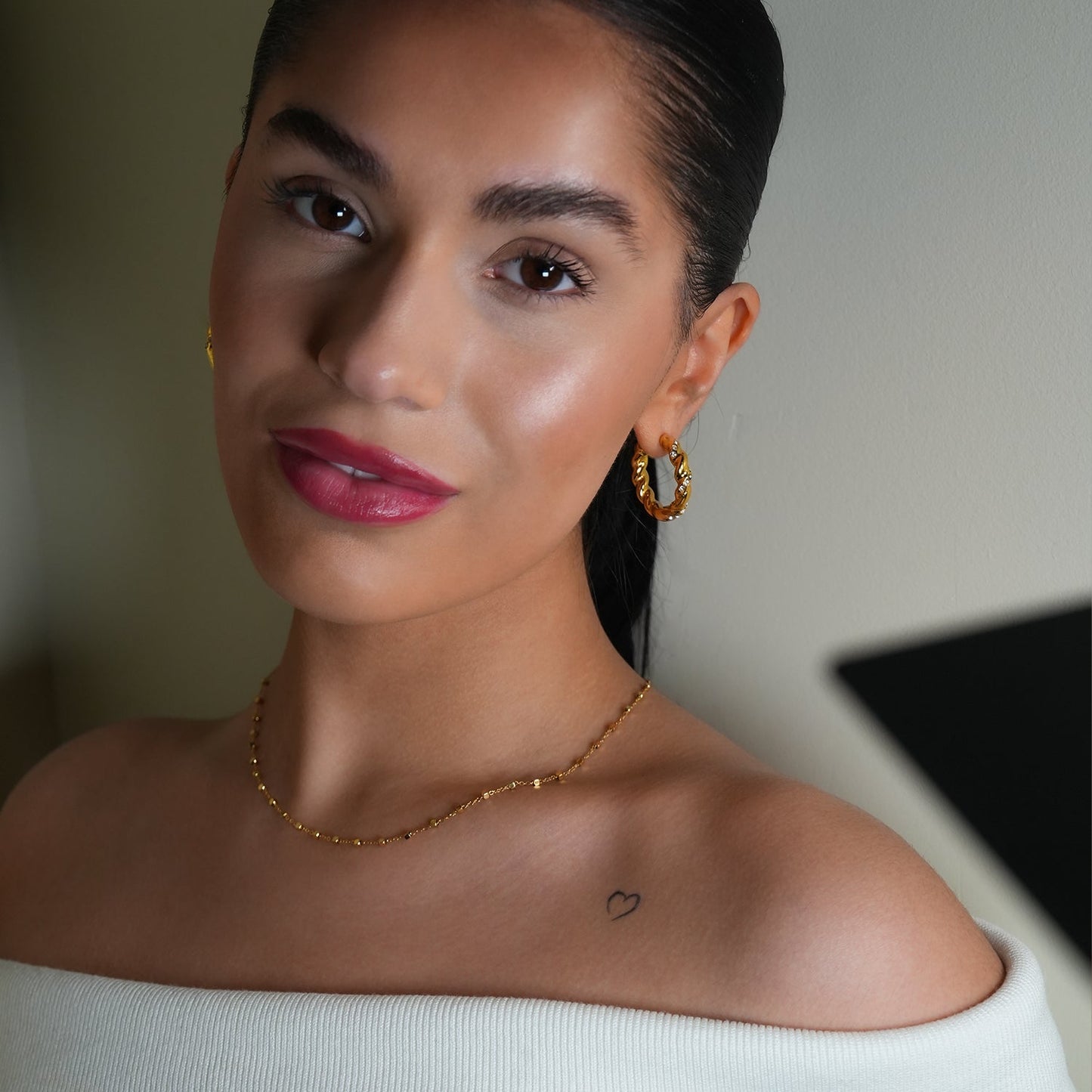 Style KAMENZ: Twisted Textured Hoop Earrings with Zirconia Embellishments.