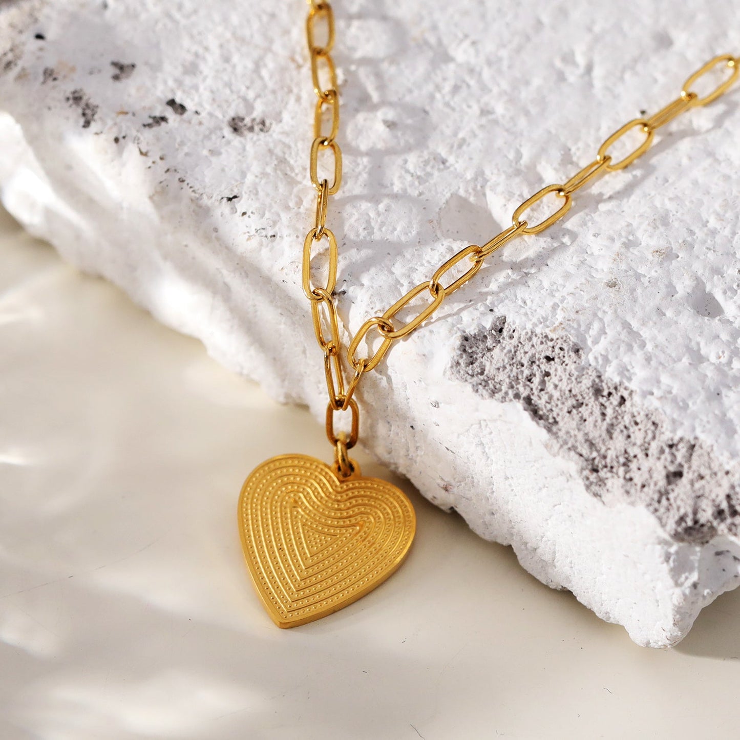 Style ALARA: Mini Paper Clip Chain Anchoring a Patterned Heart Charm in Gold