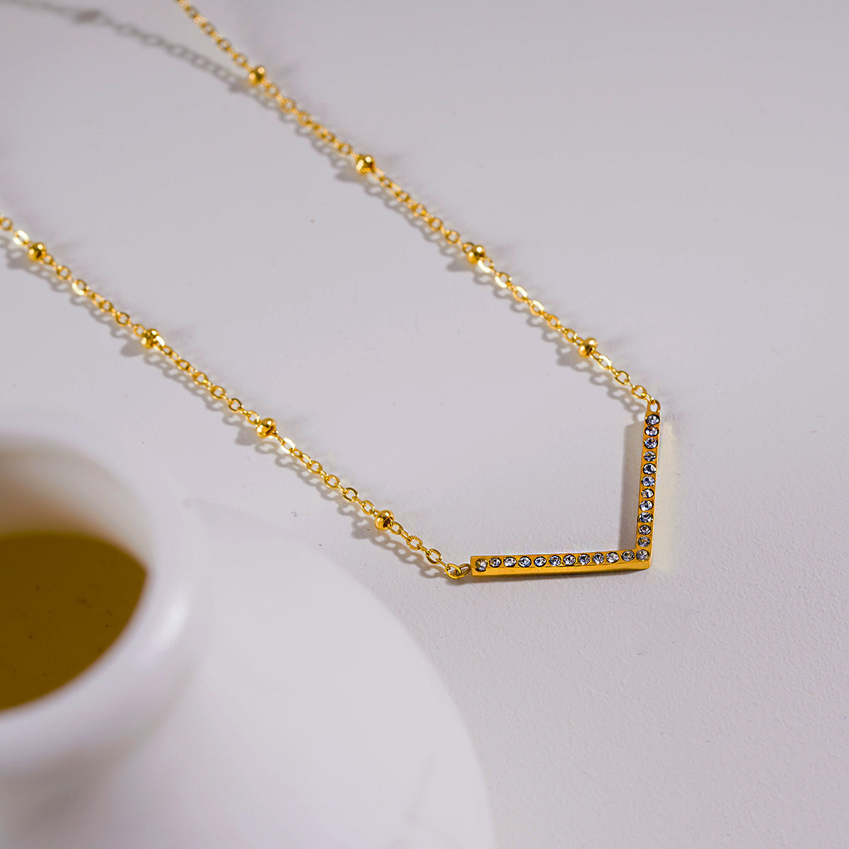 SANITA: Beaded Dainty Chain Anchoring 'V' Shaped Zirconia Embedded Pendant Charm